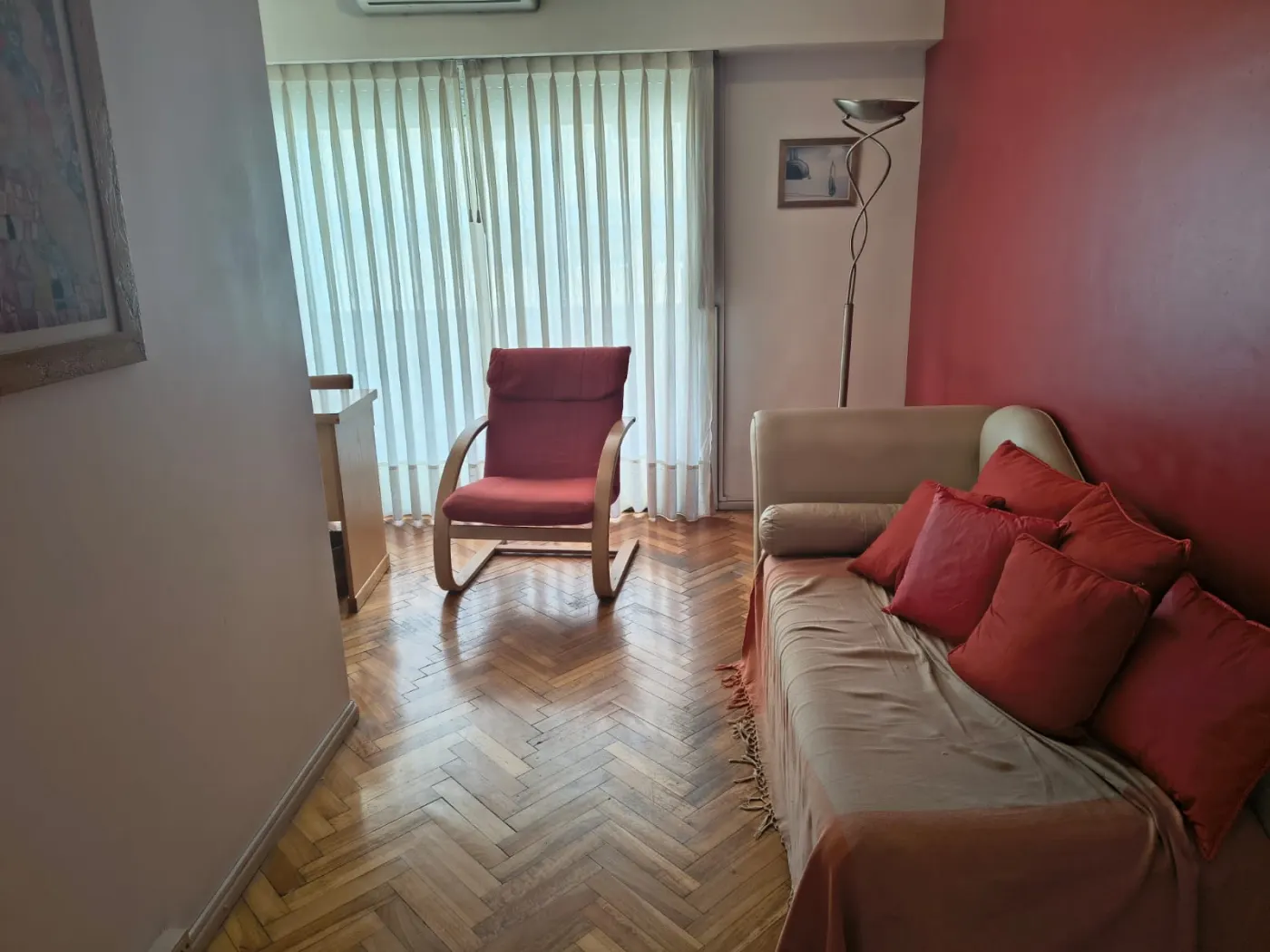 Sala del consultorio con sillón rojo junto a la ventana y diván